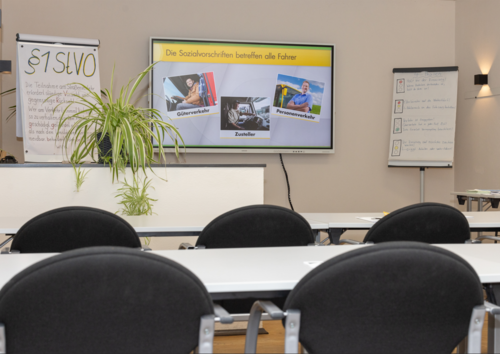 Fahrschulzimmer mit Stühlen vor einem Bildschirm