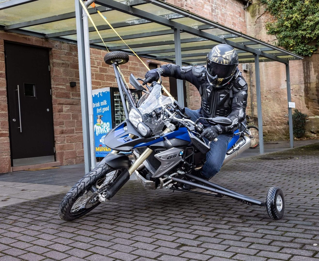 Motorradfahrer auf einem blauen Motorrad mit Stützen beim Schräglagentraining