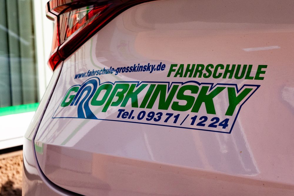 Detailaufnahme des Logos der Fahrschule Großkinsky GmbH auf dem Heck eines Autos